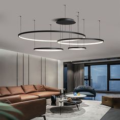 a living room with couches, tables and lamps hanging from it's ceiling