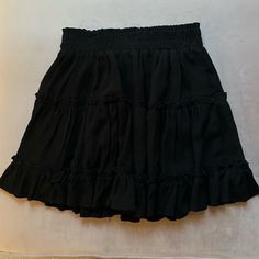 Black Skirt Never Worn. Mini. Ruffles. Super Cute. Size Small Chic Black Skort With Elastic Waistband, Black Skirt With Elastic Waistband For Summer, Black Pleated Skirt For Day Out, Black Relaxed Mini Skirt For Summer, High Waist Black Skirt With Elastic Waistband, Black Flowy Bottoms For Day Out, Black Flowy Mini Skirt For Day Out, Black Tiered Skort For Summer, Black Tiered Skirt For Night Out