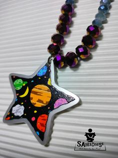 a necklace with a star and planets on it