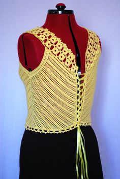 a mannequin with a yellow crochet top on it's back