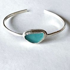 Sea glass jewelry This aqua sea glass bracelet is surely a timeless piece of sea glass jewelry!  The simplicity of design and the stunning color of the sea glass makes it so. What a special keepsake of the sea for a beach lover.  It would also be a beautiful handmade birthday gift for a sister. The genuine sea glass is nestled in a bezel setting of fine silver and placed on a handcrafted sterling silver cuff.  The best features of this sea glass bangle are that it is easy to put on and take off Sea Glass Bangle, Sea Glass Jewellery, Handmade Birthday Gifts, Sea Glass Bracelet, Glass Bangles, Silver Gift Box, Beach Lover, Women Birthday, Glass Bracelet