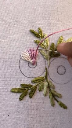 someone is stitching flowers on the fabric