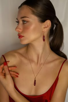 The Daria Red Quartz Earrings are perfect for the woman who wants to add a touch of classic elegance to her look. Handcrafted with deep red quartz crystals and 14k gold-filled ear wires these earrings are sure to make you feel confident and stylish, whether you're dressing up for a special occasion or just adding a little something extra to your everyday style. Pair with the Daria Red Quartz Necklace for a perfect match. -14k gold-filled components -Faceted red quartz -Hypoallergenic, suitable f Red Necklace Outfit, Red Quartz, Silk Bag, Gold Bond, Bag Inside, Red Necklace, Pink Jewelry, Sustainable Packaging, Red Earrings