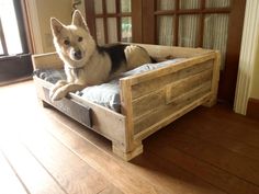 a dog laying on top of a wooden bed