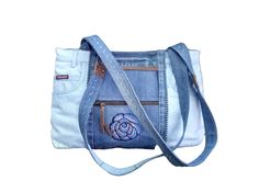 a denim purse with an embroidered rose on the front and zippered closures is shown