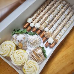 there are many different types of pastries in the box on the table and one is white