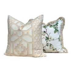 two pillows with decorative designs on them, one in white and the other in beige