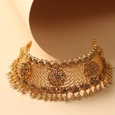 Description This glamorous yet simple choker set is designed for your festive days. The Yuthi classic choker from Tarinika is crafted with geometric filigree patterns with floral nakshi based on an antique gold tone with dangling metal balls & pearls. Whether it’s a wedding or a special event - this will be a perfect companion. Details & Specifications: Materials used: Brass Alloy with Antique Gold Plating Weight – Choker 99.71 gm, Earrings 38.33 gm Length – Choker 17.5 cm, Earrings 5 cm Make it Simple Choker, Filigree Pattern, Choker Set, Metal Ball, Gold Plating, Special Event, Antique Gold, Special Events, Beautiful Jewelry