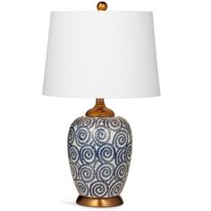 a blue and white table lamp with a white shade on the top, against a white background