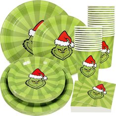 the grin face plates, cups and napkins are green with red santa's hats on them