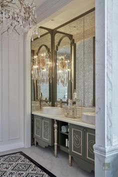 a fancy bathroom with chandelier and double sinks