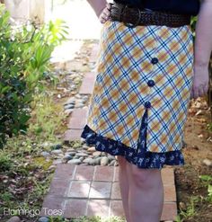 a woman wearing a skirt with a blue and yellow checkered design