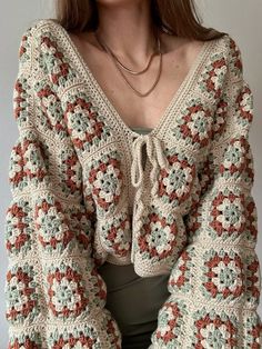 a woman is wearing a crocheted sweater