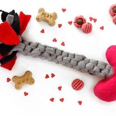 a dog toy is tied to a rope with hearts and other toys around it on a white surface