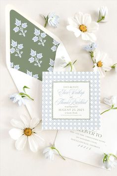 the wedding stationery is laid out with daisies