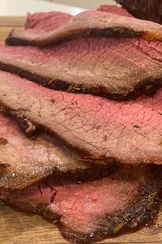 sliced meat sitting on top of a wooden cutting board