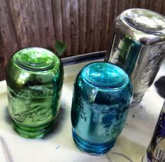 three glass jars sitting on top of a table