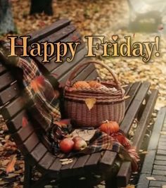 a wooden bench with a basket and apples sitting on it's back in the fall leaves