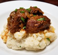 a white plate topped with mashed potatoes and meat