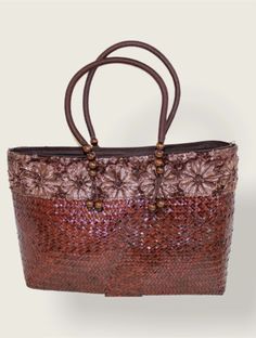 Burgundy handbag made from bamboo straw with a flower design at the top. Spring Beach Bags With Beaded Details, Brown Crochet Bag With Handles For Beach Season, Summer Beaded Rectangular Beach Bag, Spring Beach Beaded Bags, Beaded Straw Bag For Everyday Summer Use, Bohemian Beaded Rectangular Beach Bag, Beige Flower-shaped Shoulder Bag For Beach, Handmade Brown Shoulder Bag For Beach Season, Beaded Bag For Everyday Use During Beach Season