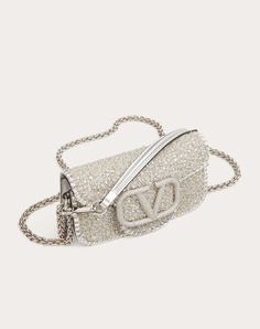 Valentino Garavani Locò small shoulder bag embroidered with leather trim and with VLogo Signature element covered in Swarovski® crystals. Equipped with both a detachable sliding chain strap and a detachable handle, this accessory can be worn as a crossbody/shoulder bag or carried as a handbag. - Palladium-finish hardware - Magnetic closure - Removable leather handle - Shoulder strap with removable sliding chain - Nappa leather lining. Interior: one slip pocket - Shoulder strap drop length: min 3 Valentino Messenger Bag, Designer Evening Bag With Adjustable Strap, Designer Silver Embellished Shoulder Bag, Luxury Embellished Clutch Shoulder Bag, Luxury Baguette Shoulder Bag For Party, Luxury Embellished Crossbody Evening Bag, Designer Embellished Rectangular Shoulder Bag, Luxury Embellished Formal Shoulder Bag, Luxury Embellished Top Handle Shoulder Bag