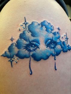 a woman's back shoulder with clouds and stars painted on the upper part of her stomach