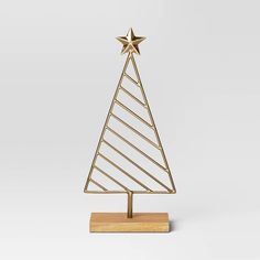 a small gold christmas tree on a wooden stand with a star on the top and bottom