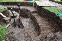 an open pit with shovels and gardening tools in it