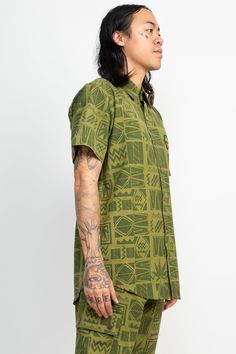 Description: Score some vibes from a 90's concert with this Rasta Print Short Sleeve Shirt! Perfect for warm summer days, its made from breathable cotton and features vibrant eye-catching leaf pattern. Perfect for music festivals and reggae shows, this shirt will show off your Rastafarian beliefs with style. It's comfortable, stylish, and perfect for expressing your love of music and chill summer Rasta vibes. Get your hands on the 90's Print Rasta Short Sleeve Shirt and make a bold statement wit Green Summer Streetwear Tops, Spring Cotton Camp Shirt With All Over Print, Casual Short Sleeve Shirt With All-over Print For Summer, Patterned Graphic Print Cotton Camp Shirt, Patterned Graphic Print Hawaiian Cotton Shirt, Cotton Camp Shirt With All Over Print, Patterned Cotton Camp Shirt With Graphic Print, Summer Cotton Short Sleeve Shirt With All Over Print, Patterned Cotton Hawaiian Shirt With Graphic Print