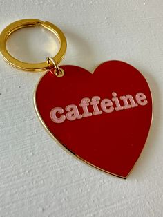 a red heart shaped keychain with the word caffeine on it