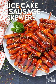 a white plate topped with cooked carrots covered in sesame seeds and ketchup