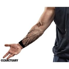 a man with a tree tattoo on his arm holding out his hand to the camera