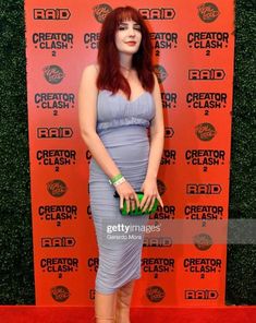 a woman in a blue dress poses on the red carpet at creation clash 2, an event