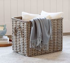 a wicker basket with towels and books on the floor