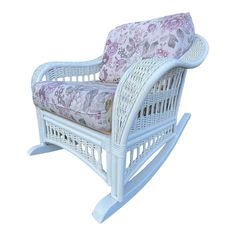 a white rocking chair with floral cushions