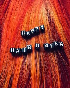 the words happy halloween spelled in black letters on top of red and orange dyed hair