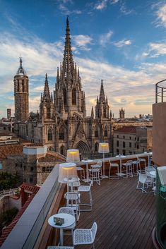 an outdoor dining area on the roof of a building with cathedrals in the background