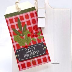 a red and white tag with the words happy holidays hanging from it's side