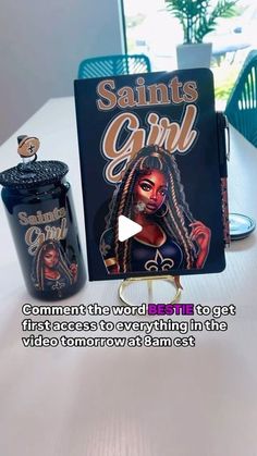 an advertisement for saint's girl on a table next to a book and candle holder