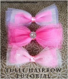 two pink and white hair bows with a diamond in the center on a brown background