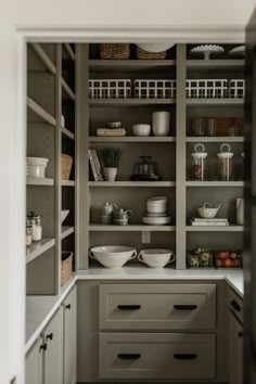 an open pantry with dishes and bowls on the shelves