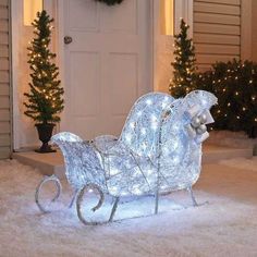 a lighted sleigh sitting in front of a door