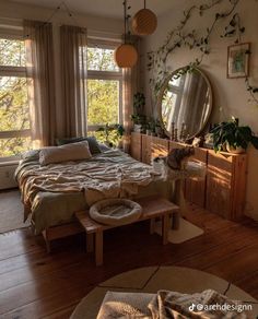 a bed room with a neatly made bed and lots of plants on the windowsill