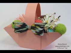 an origami box filled with different types of items and bows on top of it