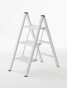 a white ladder shelf with two shelves on each side and one step up to the top