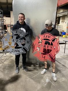 two men standing next to each other holding signs