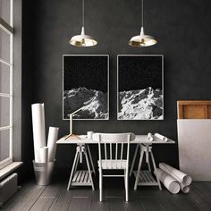 two black and white pictures hang on the wall above a dining room table with chairs