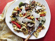 a white plate topped with lots of veggies on top of a red table