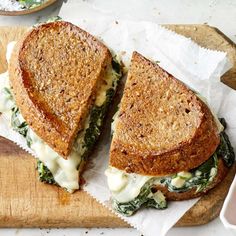 a sandwich cut in half sitting on top of a cutting board