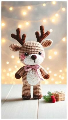 a crocheted reindeer is standing next to a present